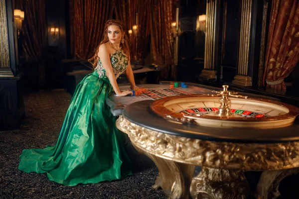 A woman in a luxurious green gown next to an ornate roulette wheel, capturing the upscale casino mood of 2777BED.
